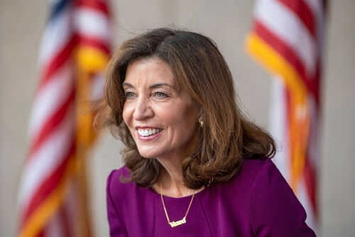 Smiling woman in a purple dress with flags behind