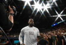 Basketball player entering arena with a crowd cheering