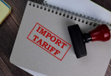 Import tariff stamp on notebook and wooden table
