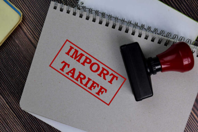 Import tariff stamp on notebook and wooden table