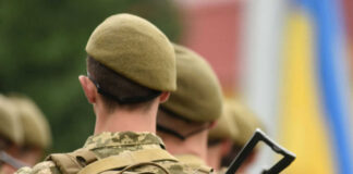 Soldiers in uniform with Ukrainian flag patches.