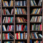 Library Bomb Threats: The New Campus Nightmare Books arranged on tall wooden shelves in a library