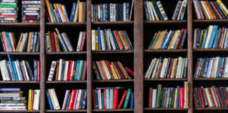 Books arranged on tall wooden shelves in a library