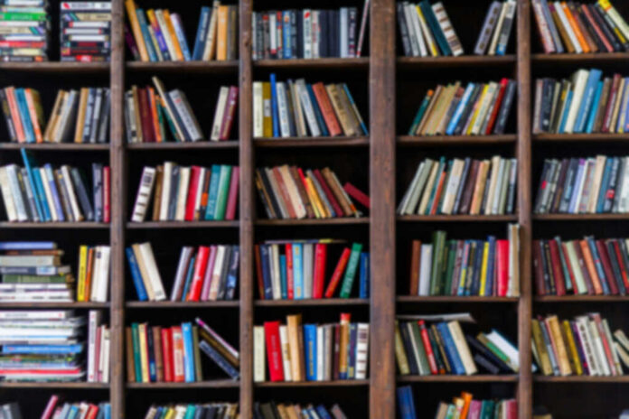 Books arranged on tall wooden shelves in a library