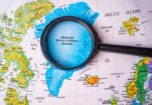 Denmark’s Greenland Maneuver: A Political Time Bomb? Magnifying glass over map of Greenland and Arctic Ocean
