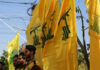 Men in military attire with yellow flags outdoors