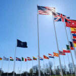 NATO Snubs Trump: US Alone in Iran Conflict Flags of multiple countries against blue sky