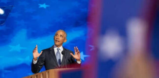 Man speaking at podium with blue starry background
