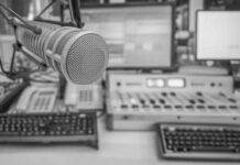 Microphone in radio studio with equipment visible