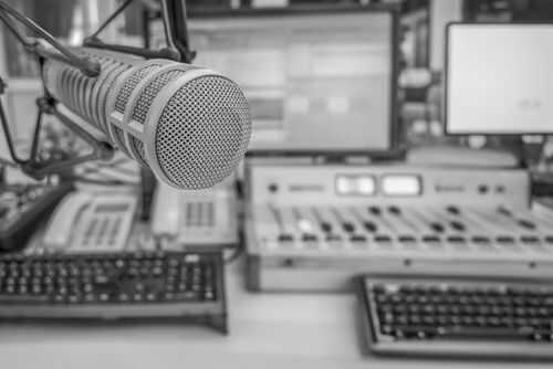 radio-station2477619137 Microphone in radio studio with equipment visible