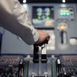 Wealthy Flee as Airports Close Worldwide Pilot's hand operating the throttle in an aircraft cockpit
