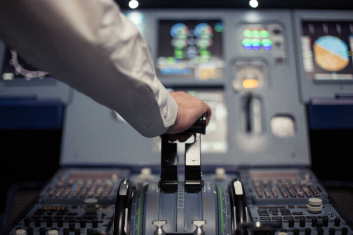 Pilot's hand operating the throttle in an aircraft cockpit