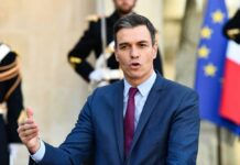 AI Overreach: Spain’s New Tool Sparks Free Speech Concerns A government official delivering a speech outdoors with flags in the background