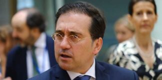 A man in a suit engaged in conversation at a formal event