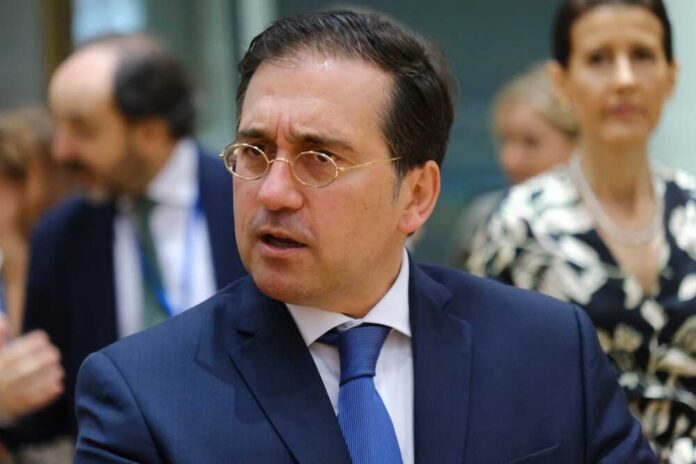 A man in a suit engaged in conversation at a formal event