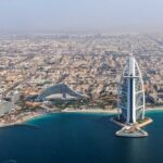 Aerial view of Dubai featuring the Burj Al Arab and surrounding buildings
