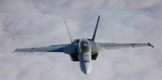 A fighter jet flying above the clouds