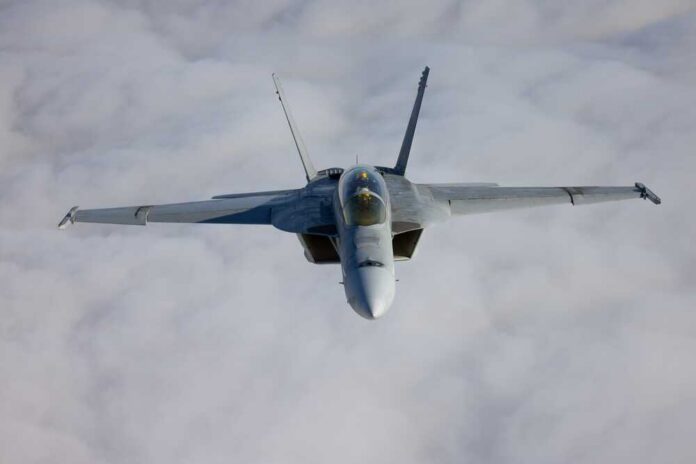A fighter jet flying above the clouds