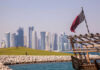 Doha skyline with Qatar flag and dhow boat