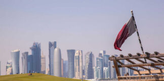 Doha skyline with Qatar flag and dhow boat