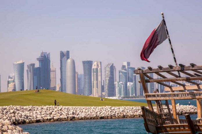 Doha skyline with Qatar flag and dhow boat