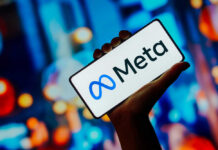 Hand holding phone displaying Meta logo