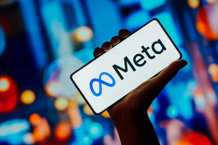 Hand holding phone displaying Meta logo