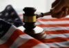 Gavel and hand on American flag.