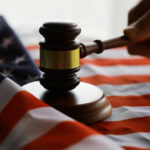Gavel and hand on American flag.