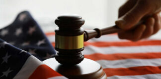 Gavel and hand on American flag.