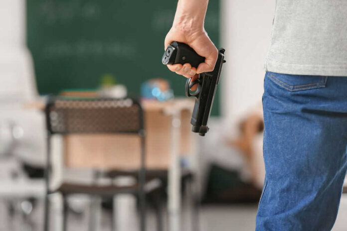 Person holding handgun in classroom setting