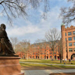 Statue overlooking a university campus with historic buildings
