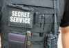 Close-up of a tactical vest worn by a security officer with 'SECRET SERVICE' label