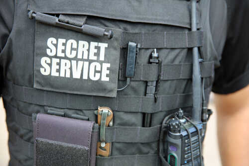 Close-up of a tactical vest worn by a security officer with 'SECRET SERVICE' label