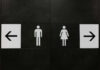 Restroom signs indicating male and female facilities with directional arrows