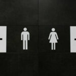 Restroom signs indicating male and female facilities with directional arrows