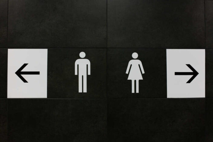Restroom signs indicating male and female facilities with directional arrows