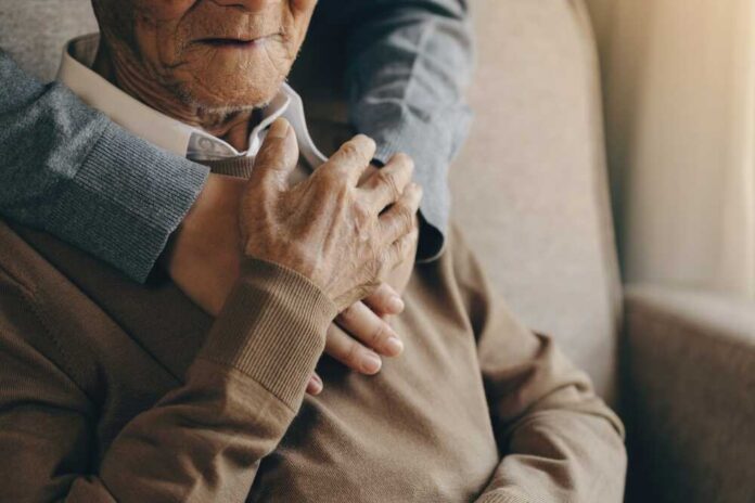An elderly man being embraced by a younger person, showcasing a moment of affection