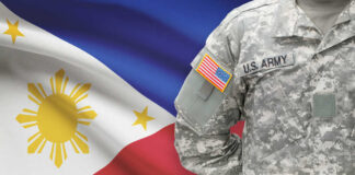 A soldier in a U.S. Army uniform with the Philippine flag in the background