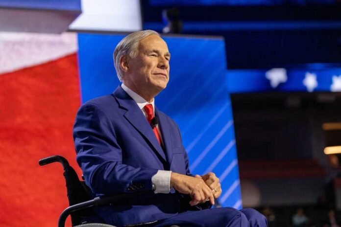 A man in a blue suit sitting in a wheelchair on a conference stage