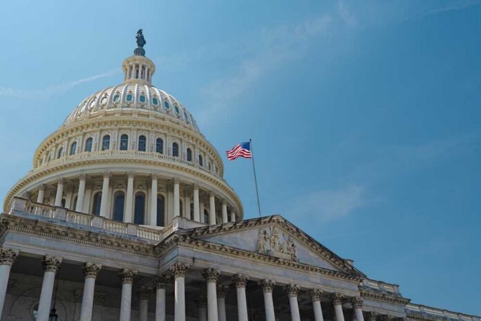 The U.S. Capitol building with an American flag flying against a blue sky