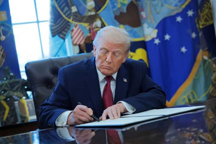 shutterstock_2715926363.jpg Donald Trump signing documents in the Oval Office