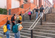 Enrollment PLUMMETS — Colleges Battle for Survival Group of students ascending outdoor stairs on a campus