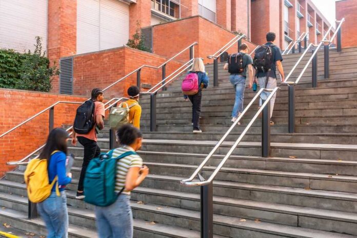shutterstock_2727038359.jpg Group of students ascending outdoor stairs on a campus