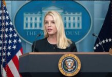A government official speaking at a podium in front of the White House seal