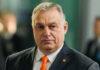 Vance’s Bold Orbán Alliance: EU Elites Furious Man wearing suit with orange tie indoors