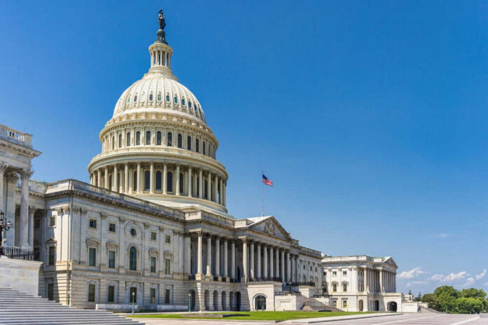whitehouseid2345816587jpg U.S. Capitol building with American flag, blue sky.