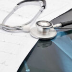Stethoscope on medical charts and X-ray image.