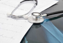 Stethoscope on medical charts and X-ray image.