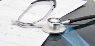 Stethoscope on medical charts and X-ray image.